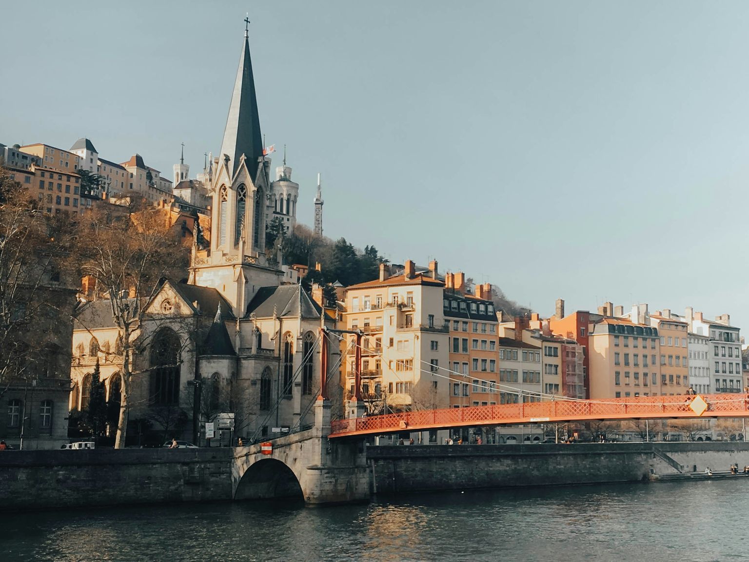 en bro över en flod med en kyrka i bakgrunden