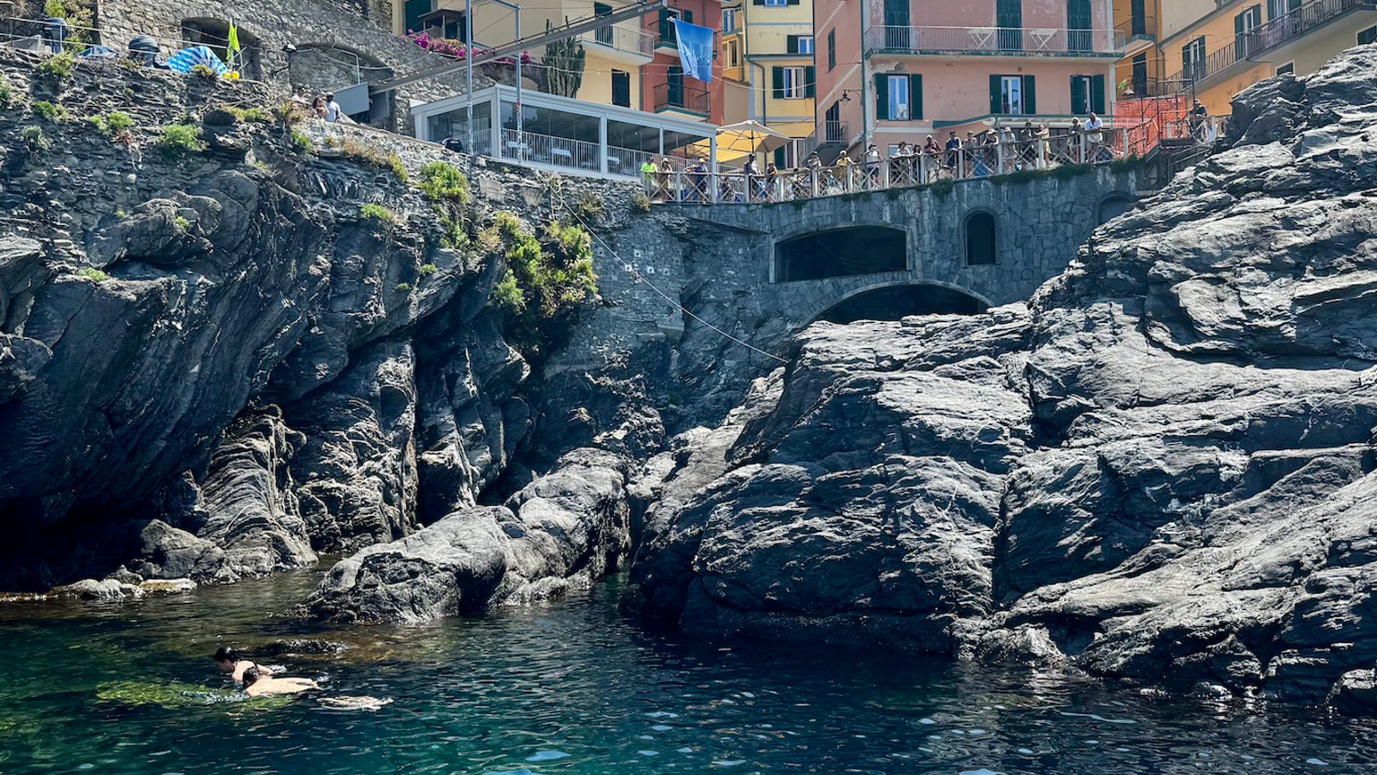 en vattenmassa omgiven av klippor och byggnader