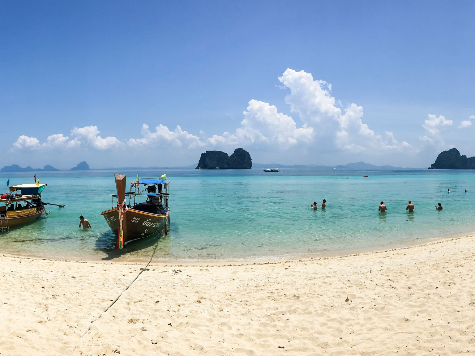 en panoramautsikt över en strand med båtar i vattnet på Koh Lanta.