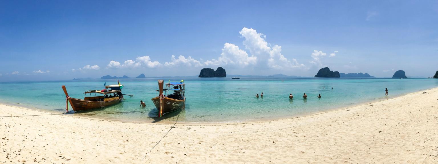 en panoramautsikt över en strand med båtar i vattnet på Koh Lanta.