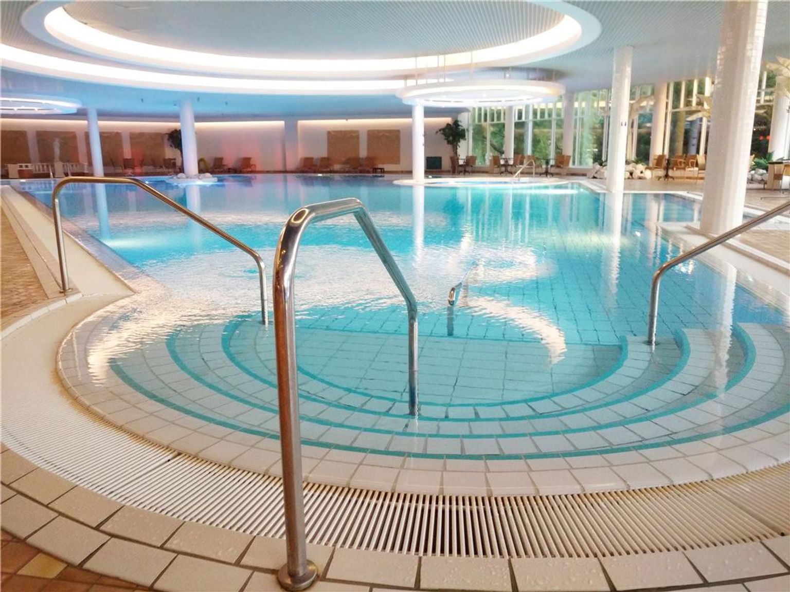 a large indoor swimming pool with stairs leading to it