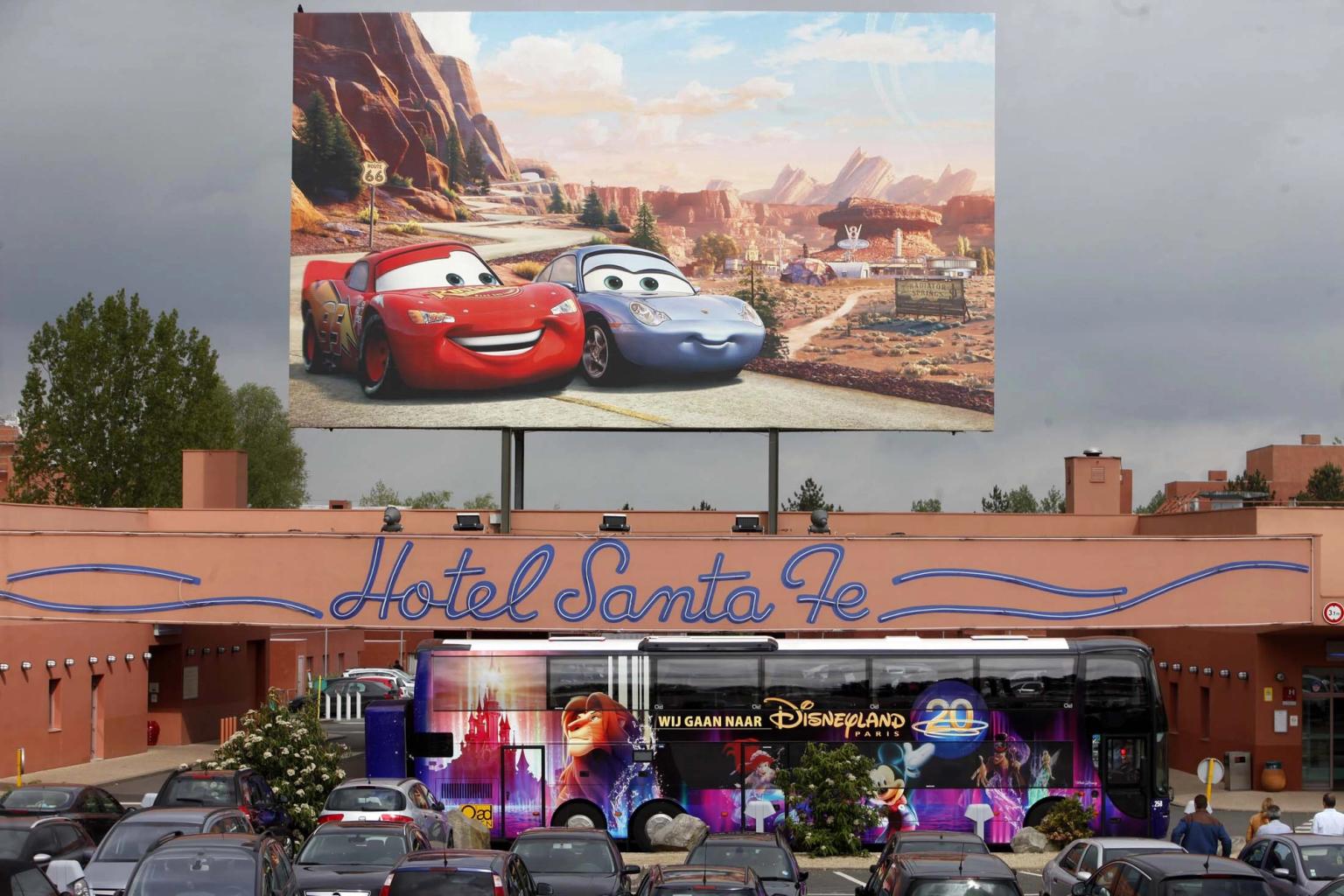 en stor billboard med bilar på det är ovanför ett hotell