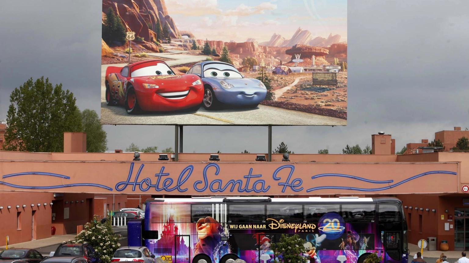 en stor billboard med bilar på det är ovanför ett hotell
