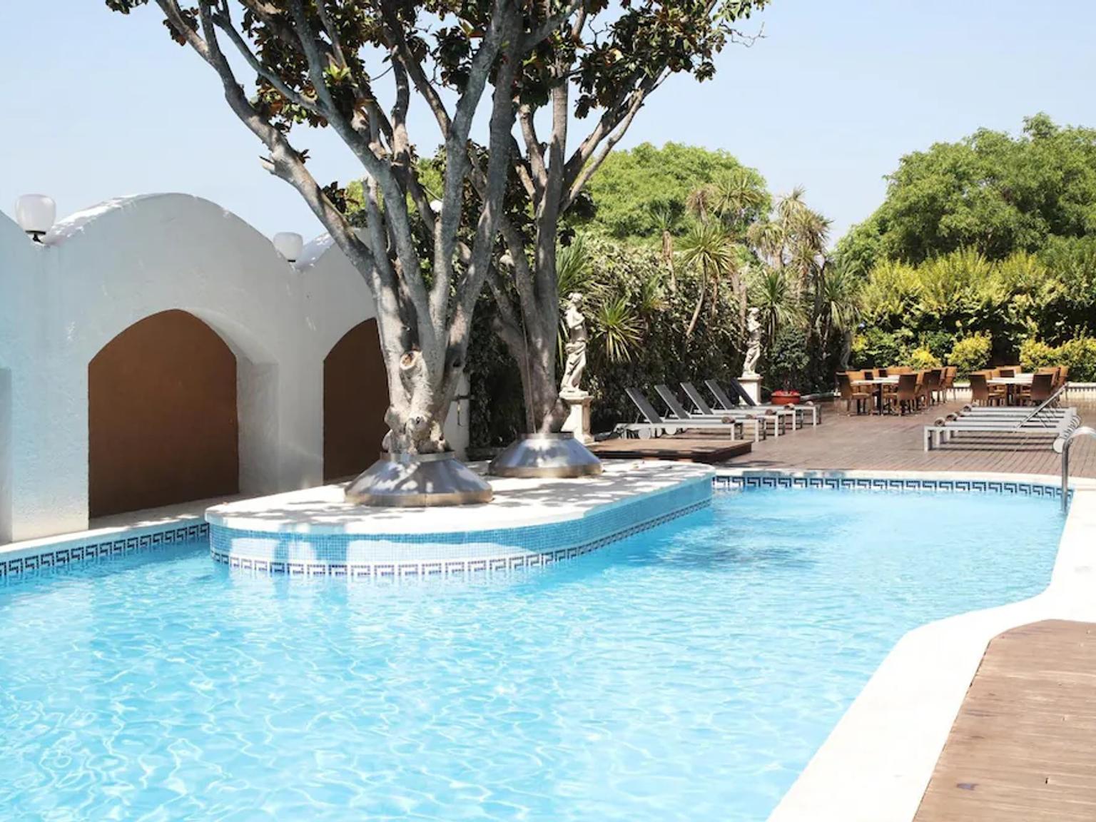 det finns en stor simbassÀng med ett trÀd i mitten av den