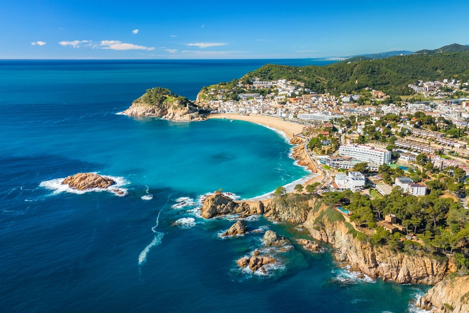 Vue aérienne d’une ville côtière avec une plage de sable, une eau turquoise et des affleurements rocheux. Tossa de Mar, Espagne
