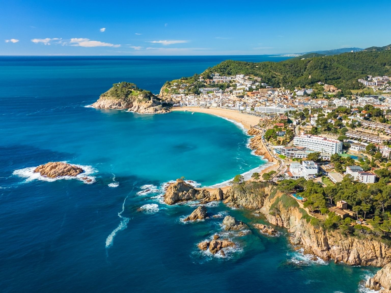 Vue aérienne d’une ville côtière avec une plage de sable, une eau turquoise et des affleurements rocheux. Tossa de Mar, Espagne