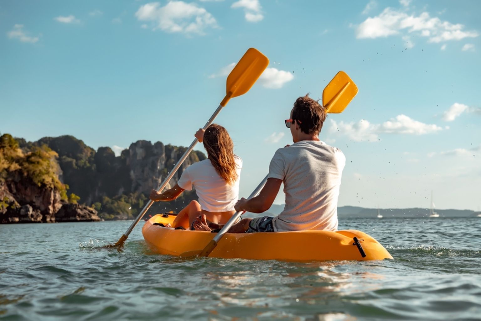 en man och en kvinna paddlar en gul kajak i havet, Krabi, Thailand