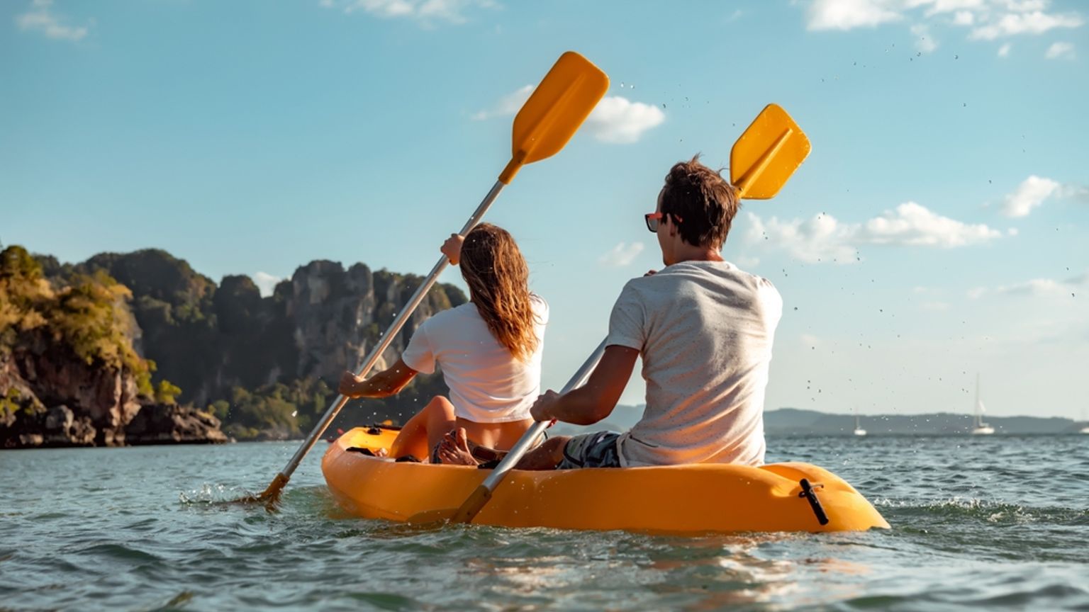 en man och en kvinna paddlar en gul kajak i havet, Krabi, Thailand