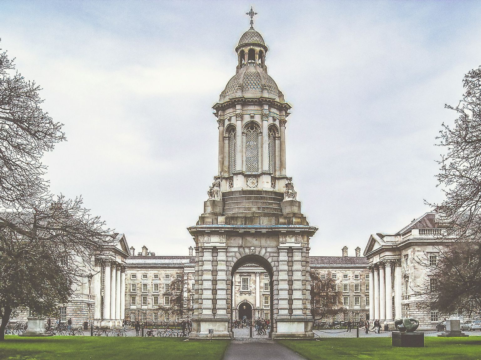 a large building with a clock tower in the middle of a park, Dublin