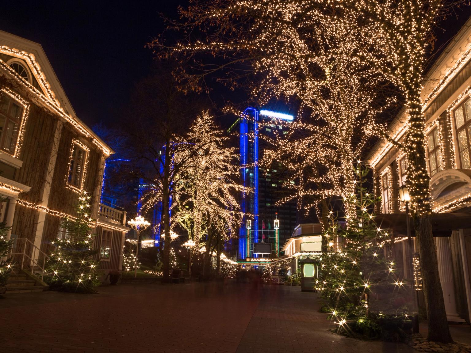 rząd budynków jest ozdobiony światłami świątecznymi nocą