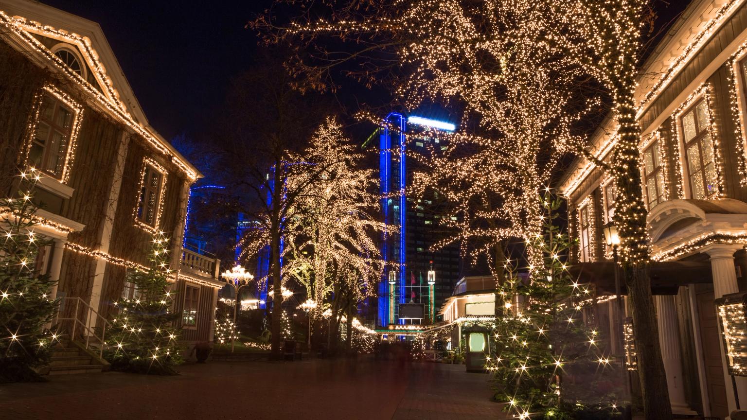 rząd budynków jest ozdobiony światłami świątecznymi nocą