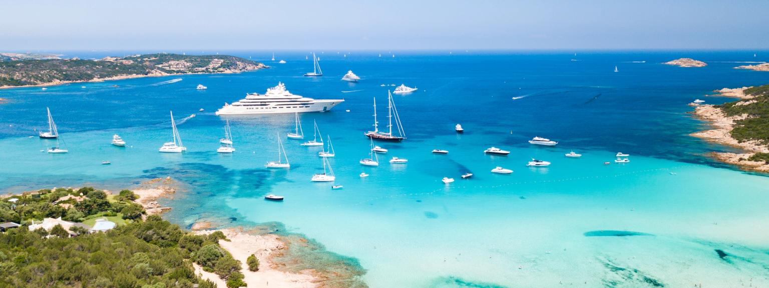 et luftfoto av en tropisk strand med båter i vannet.