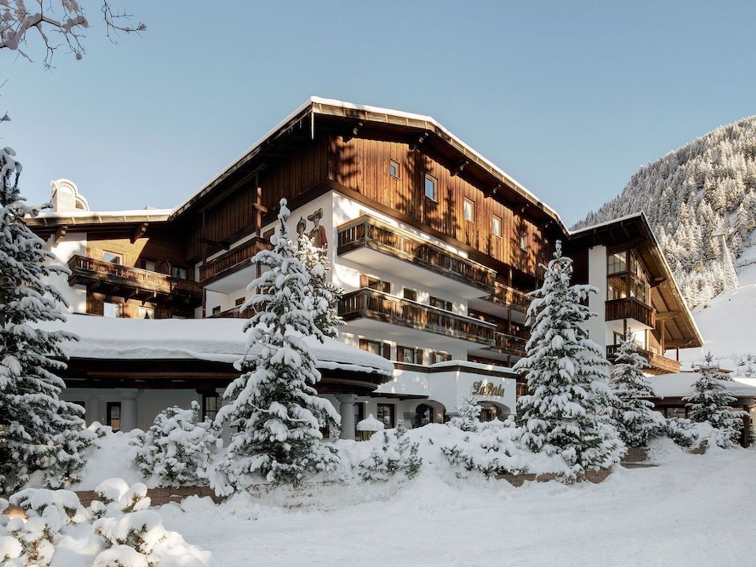 en stor trebygning omgitt av snødekte trær i fjellene, Hotel La Perla The Leading Hotels of the World, Alta Baida