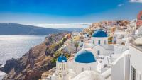 Witte klifgebouwen met blauwe koepels in Santorini met uitzicht op de Egeïsche Zee.
