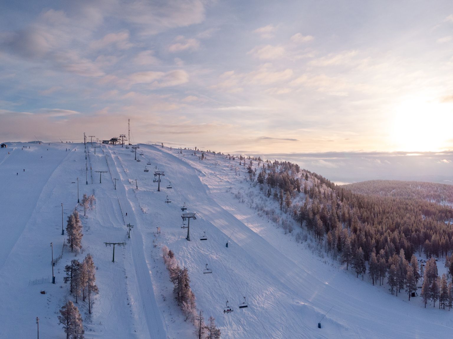 en luftig utsikt over en skibakke ved solnedgang
