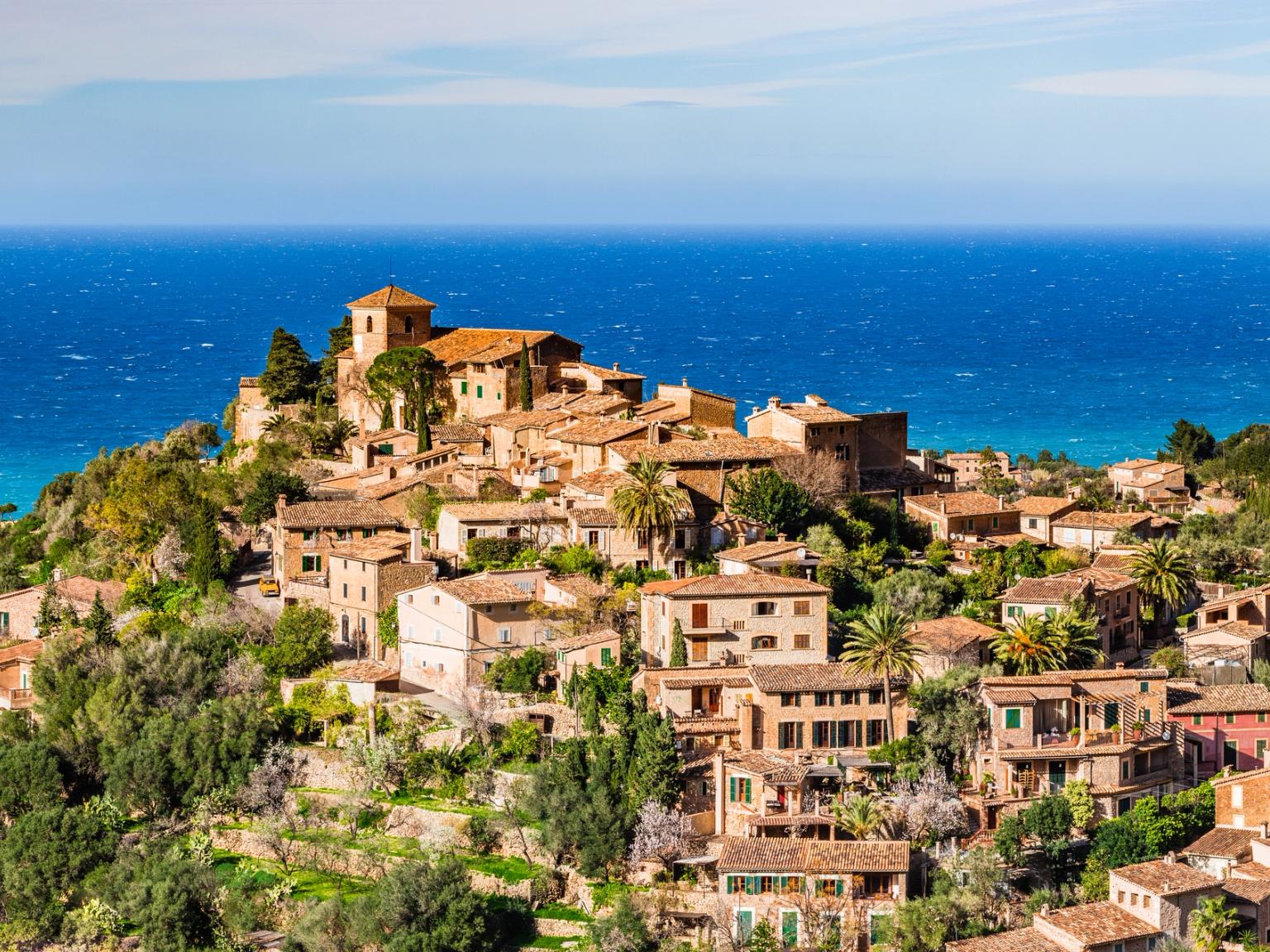 en flygvy över en liten stad på en kulle med utsikt över havet