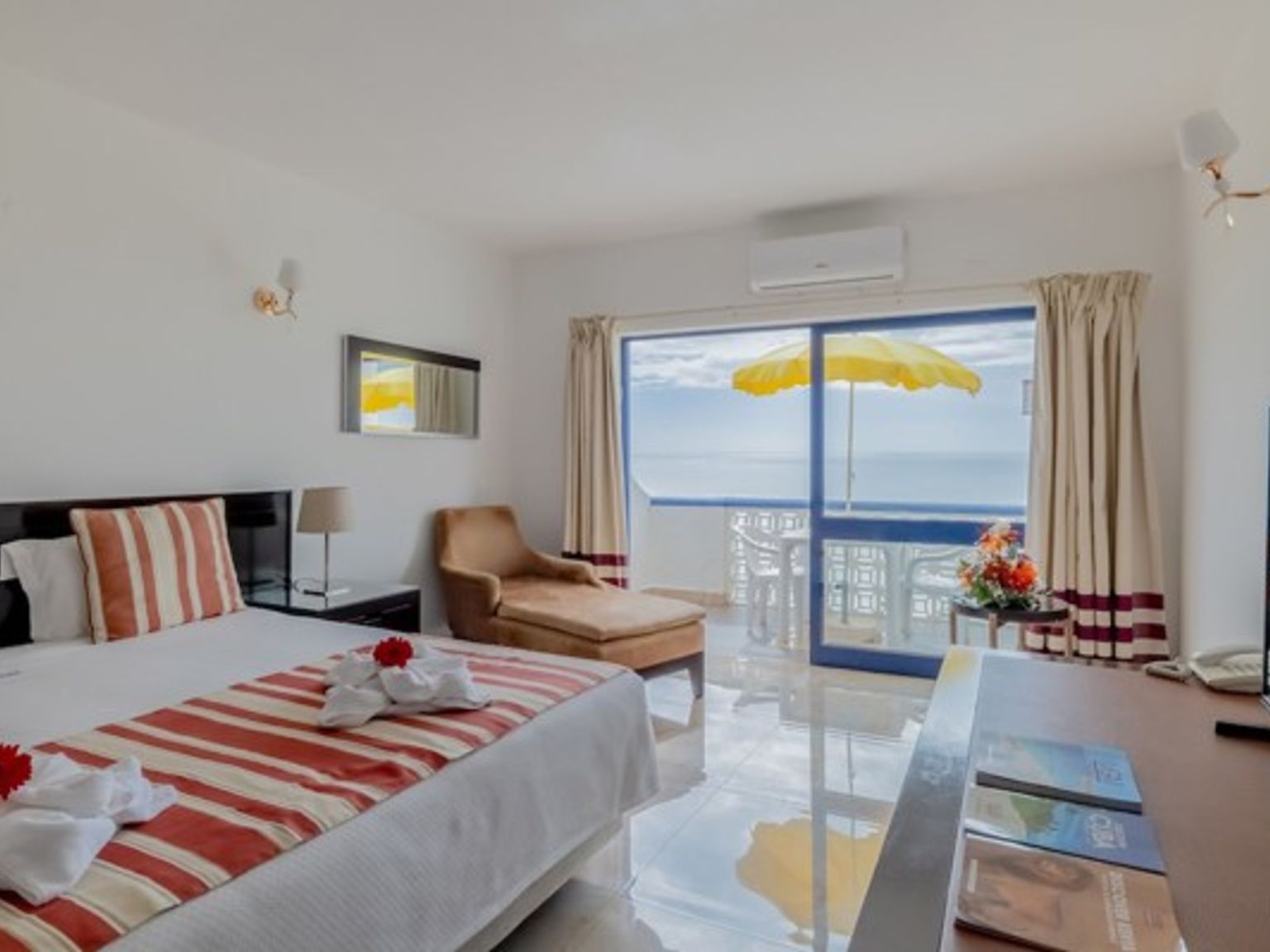 ett hotellrum med en king size-säng, stol, bord och television