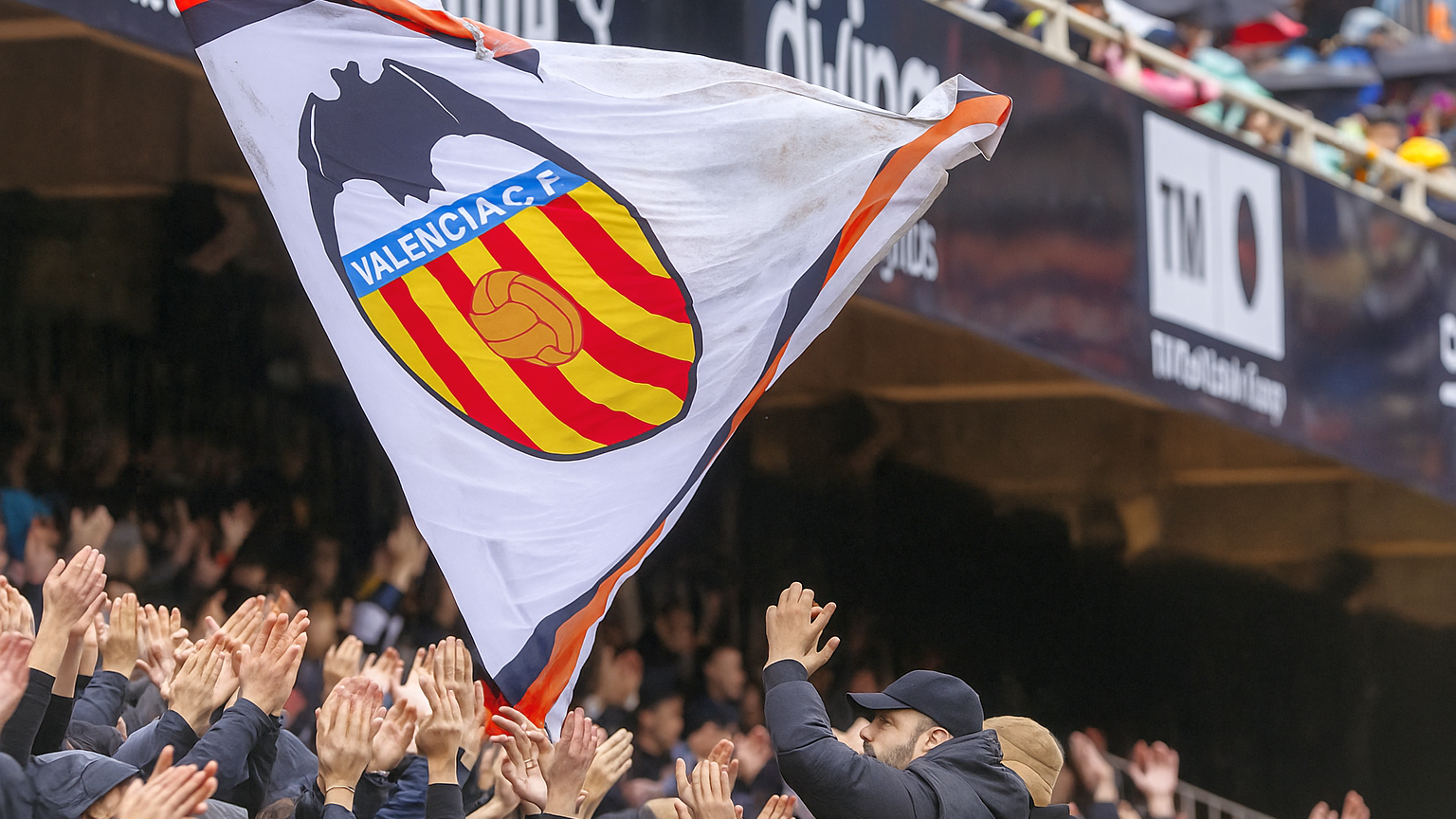 Eine Gebäudefassade mit einem "Willkommen"-Banner und einem großen, texturierten Fledermaus-Emblem.