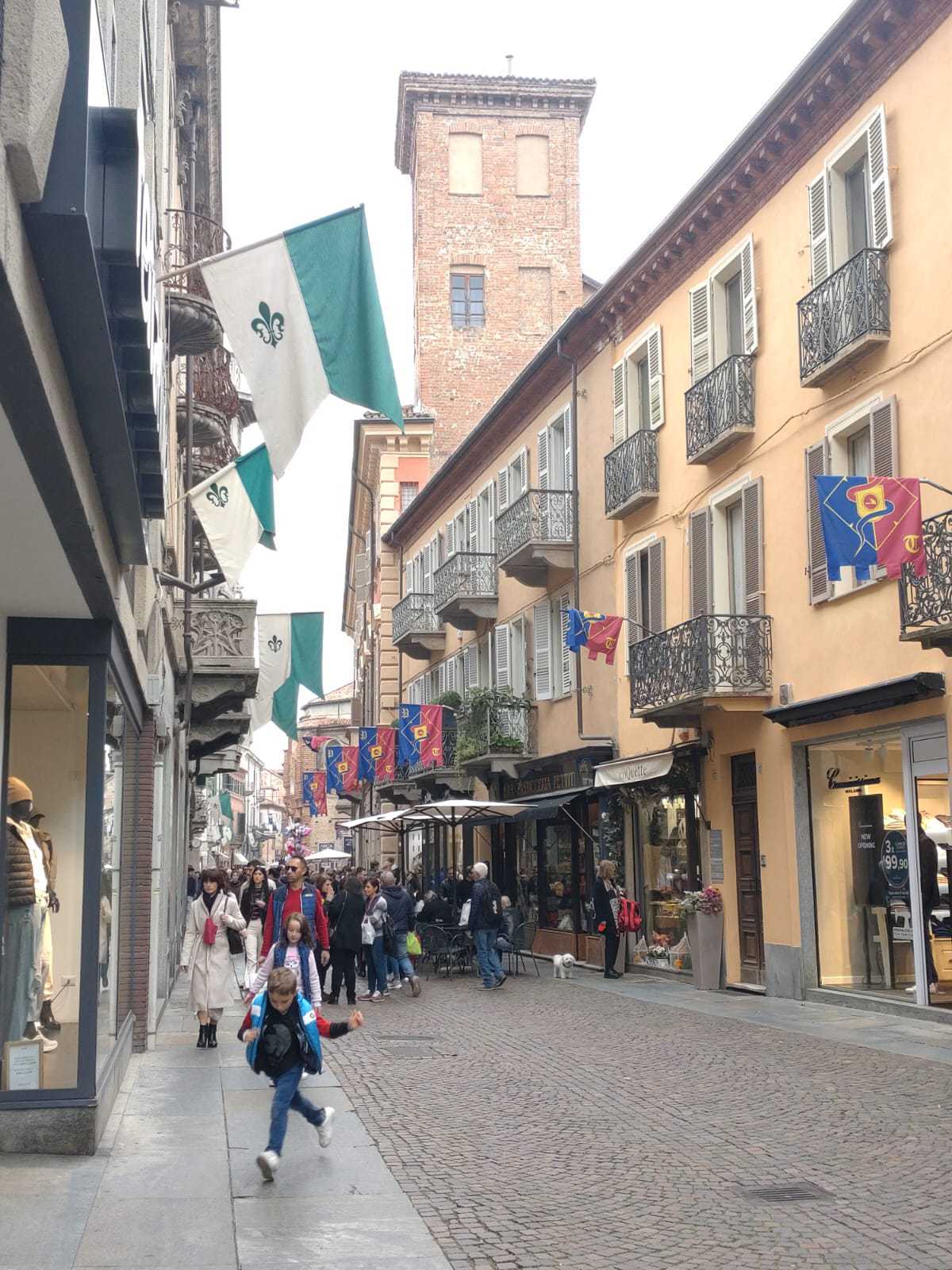 en grupp människor går nerför en kullerstensgata