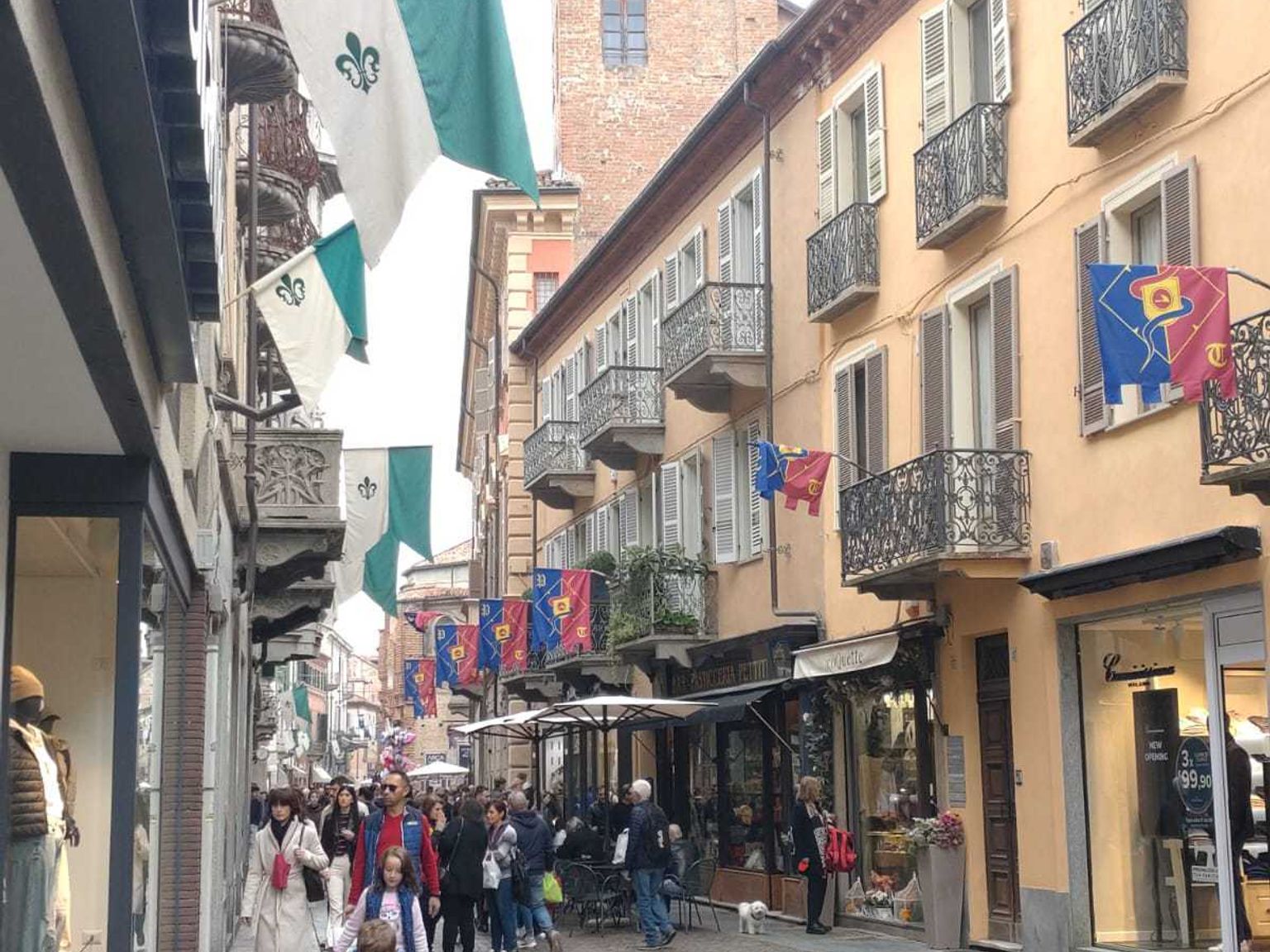 en grupp människor går nerför en kullerstensgata