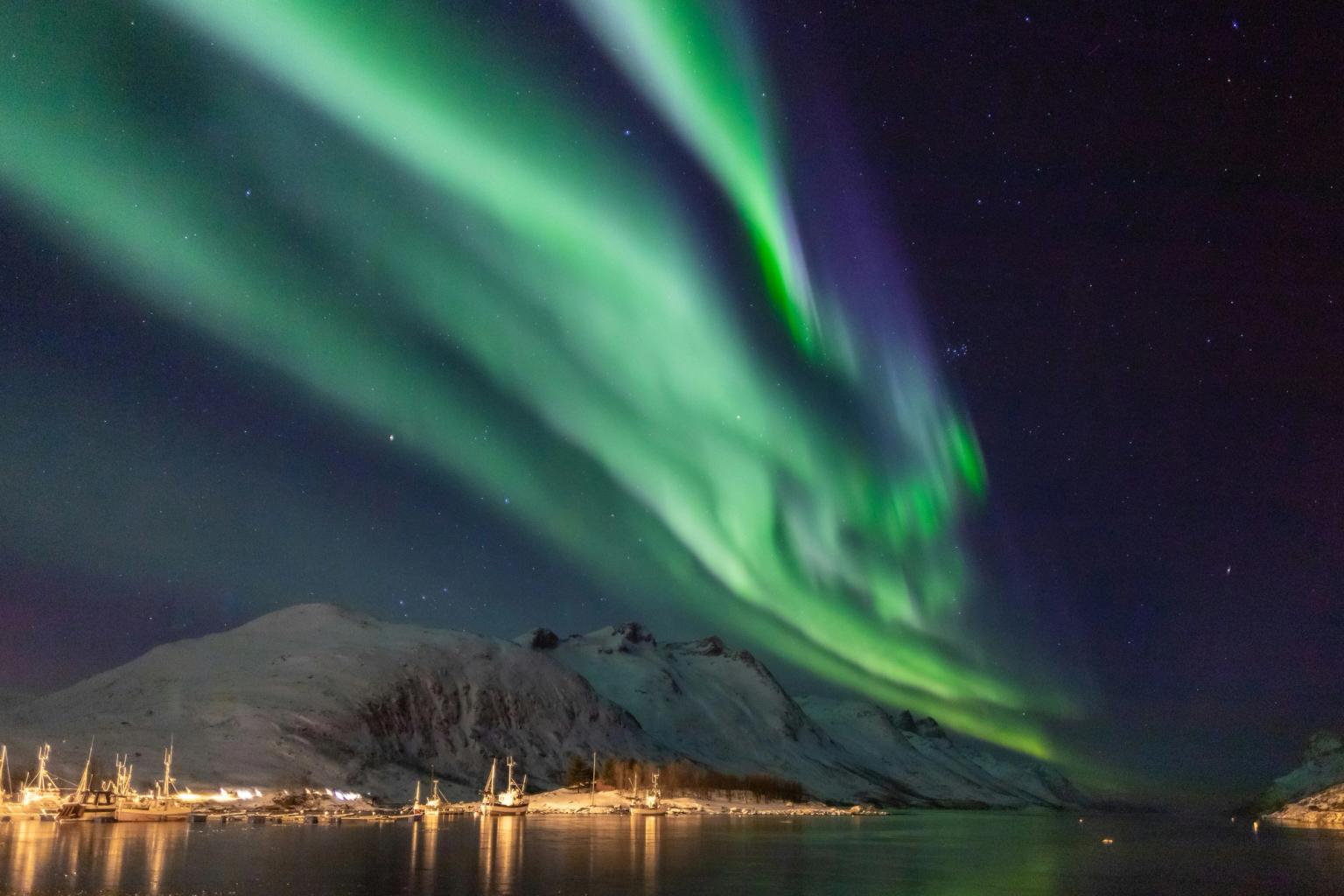 das Nordlicht scheint über einem Berg und einem Gewässer