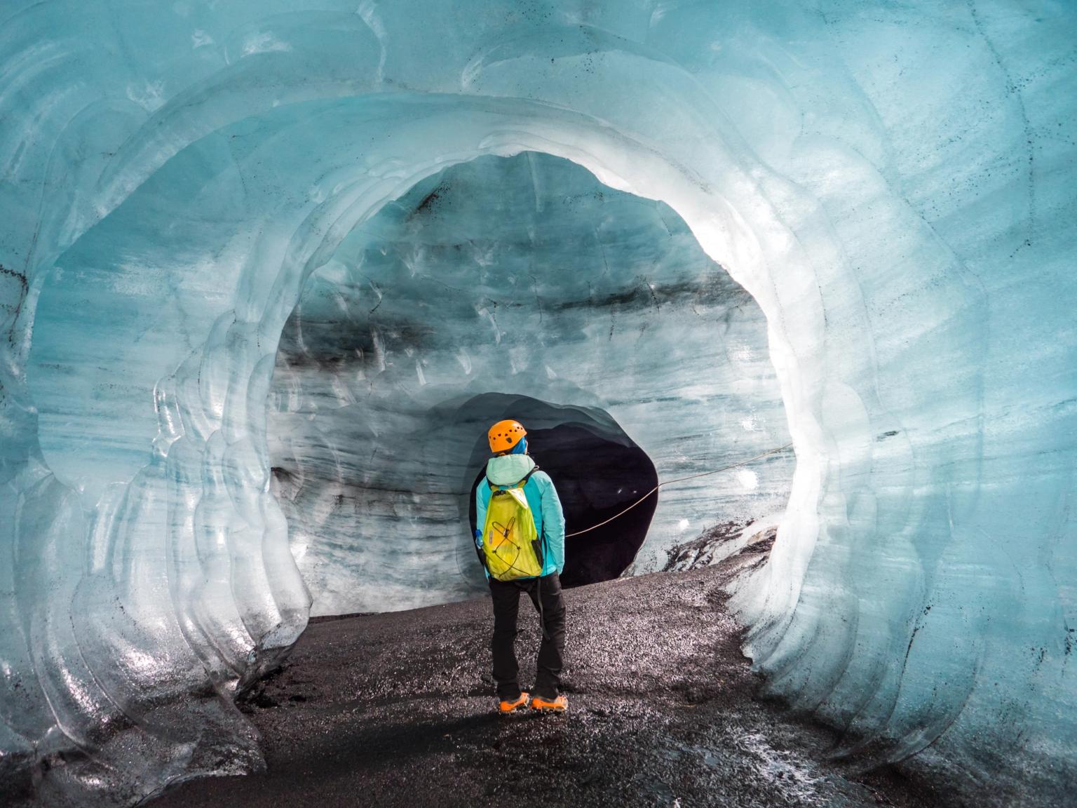 a person is standing inside of an ice cave