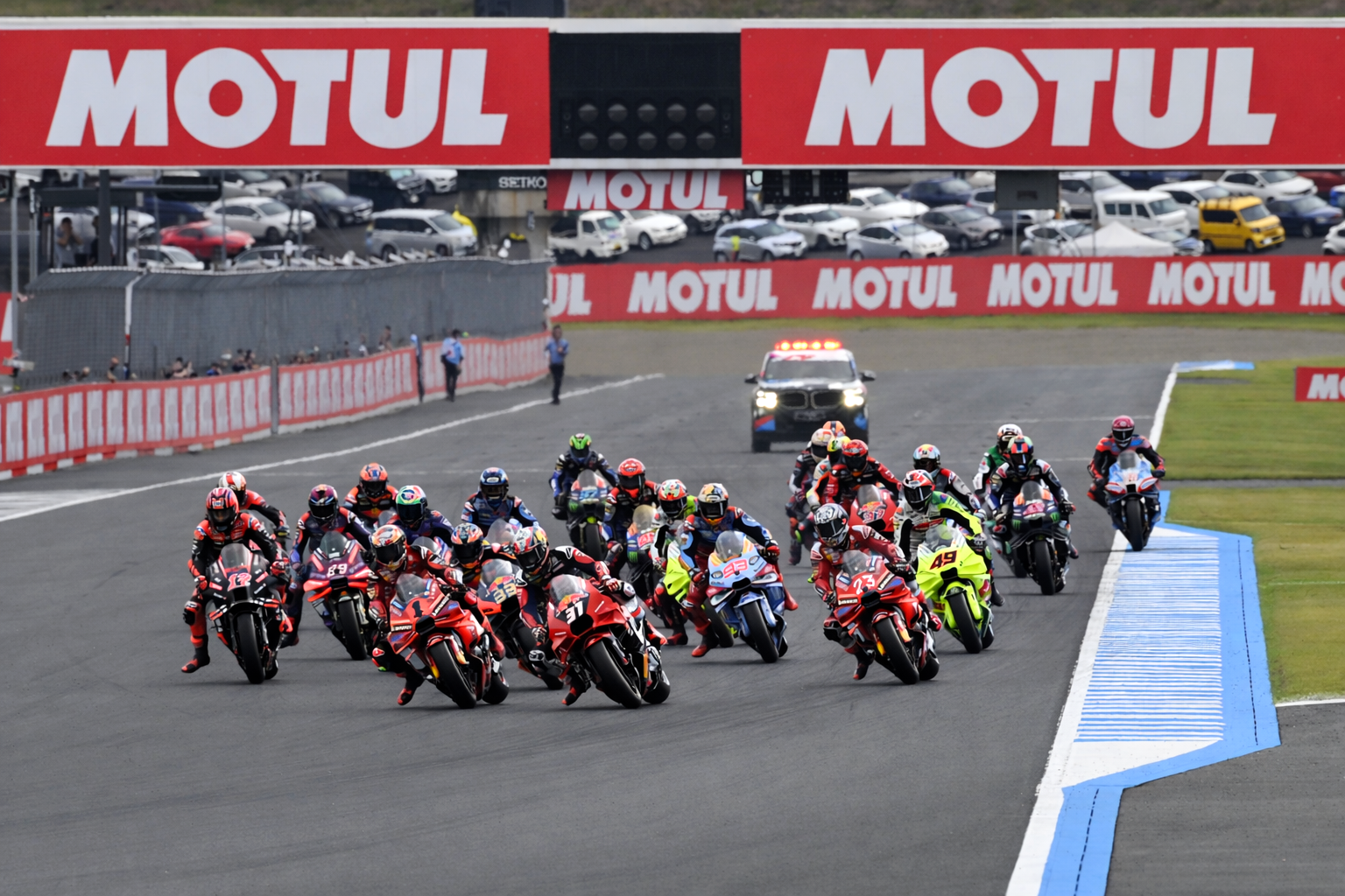 Muchos pilotos de motociclismo se inclinan en una curva en un circuito de carreras.