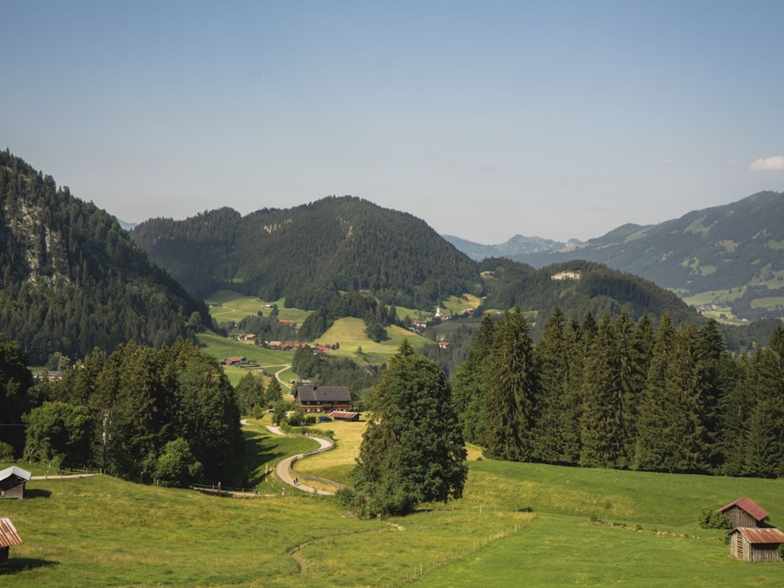 en vy över en dal omgiven av berg och träd