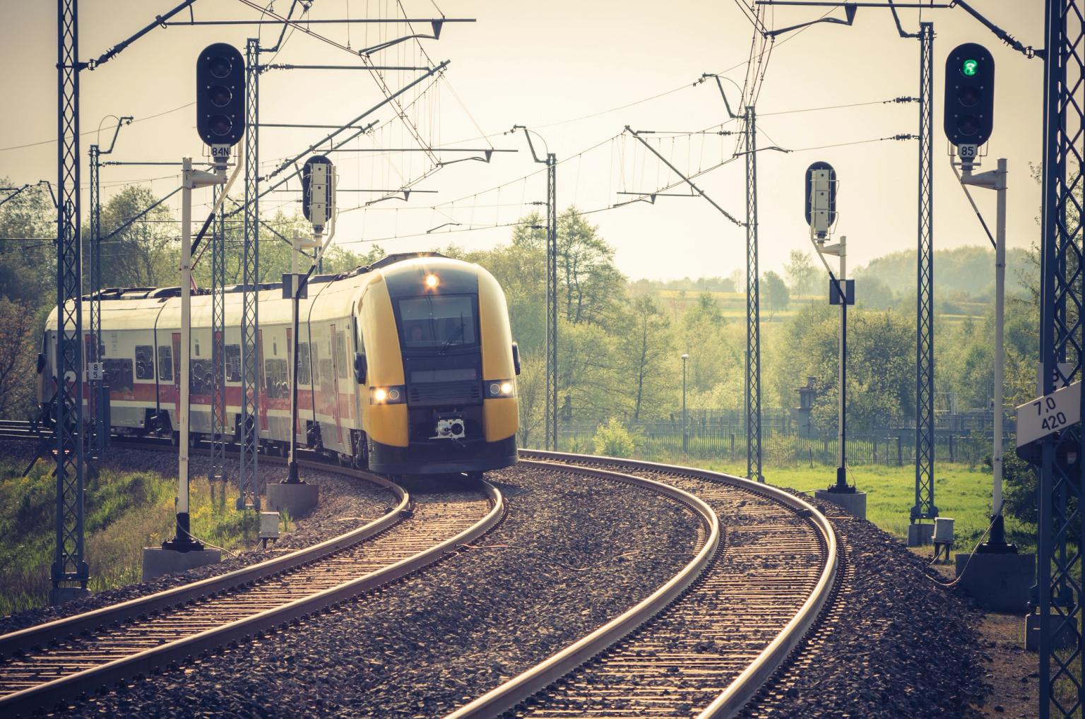 et gult og hvitt tog går ned togspor