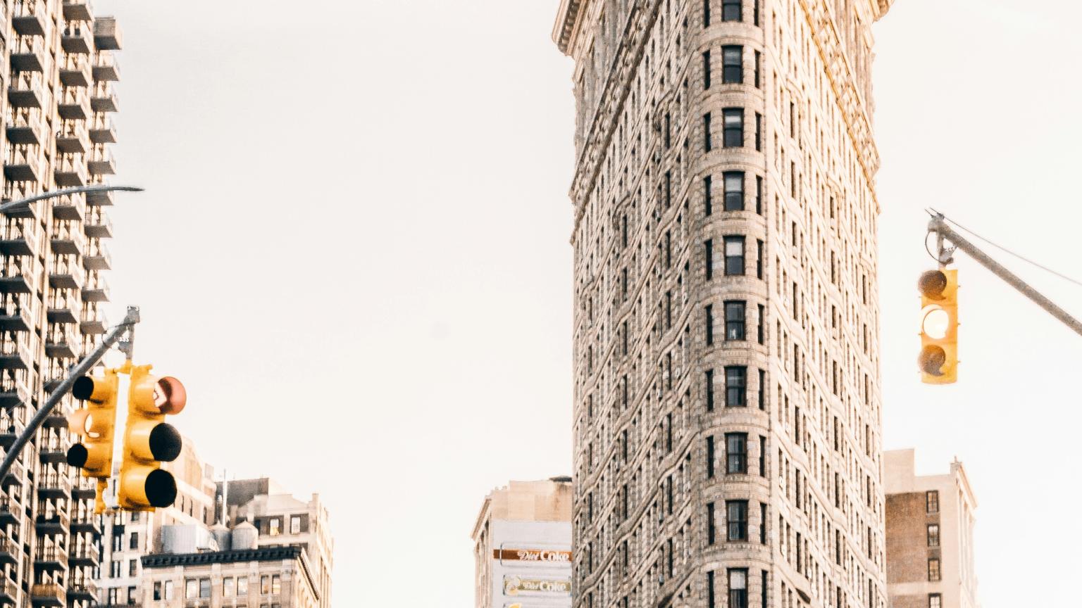 a busy city street with a tall building in the background