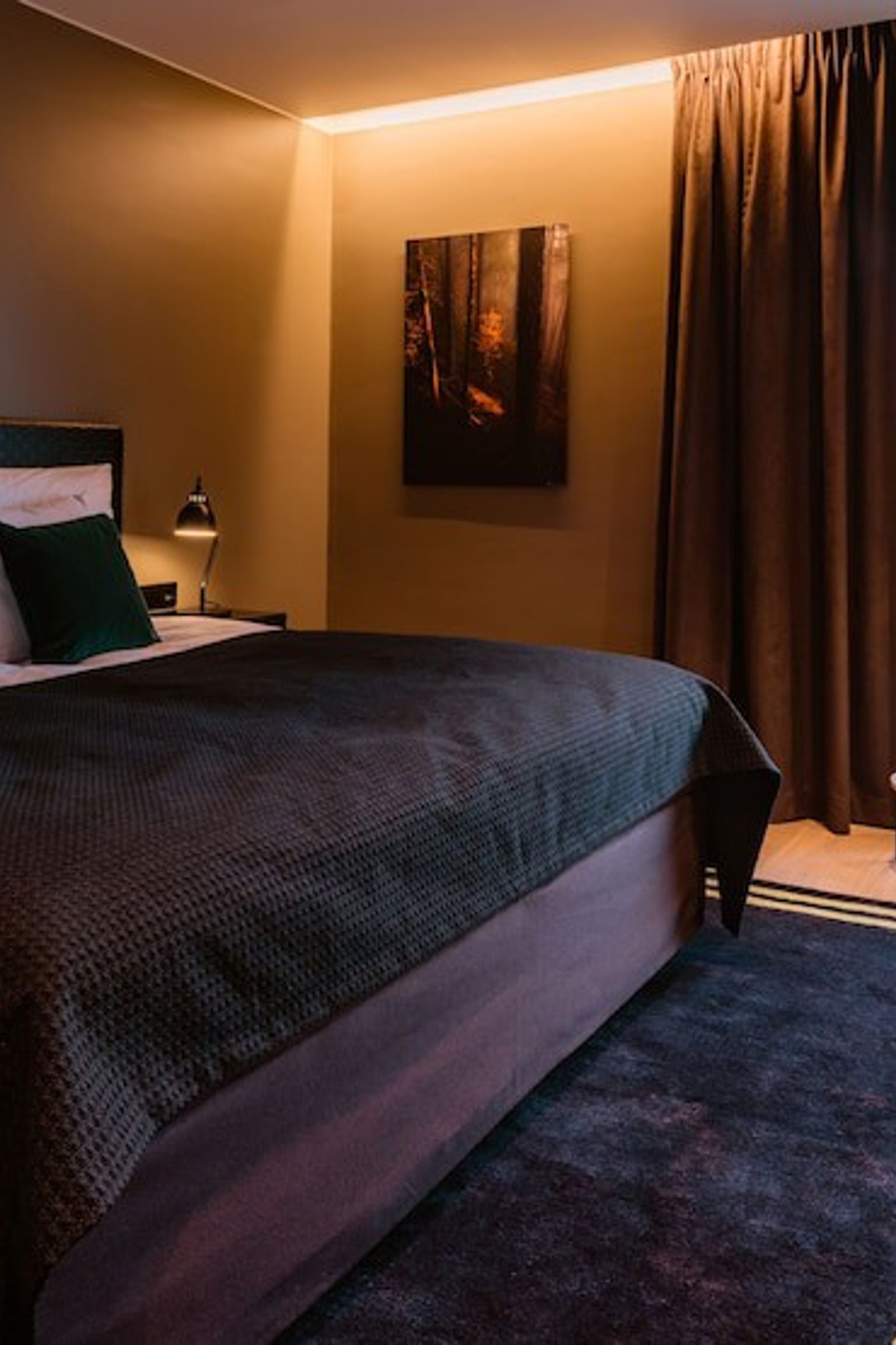 a hotel room with a large bed, chair, desk and window