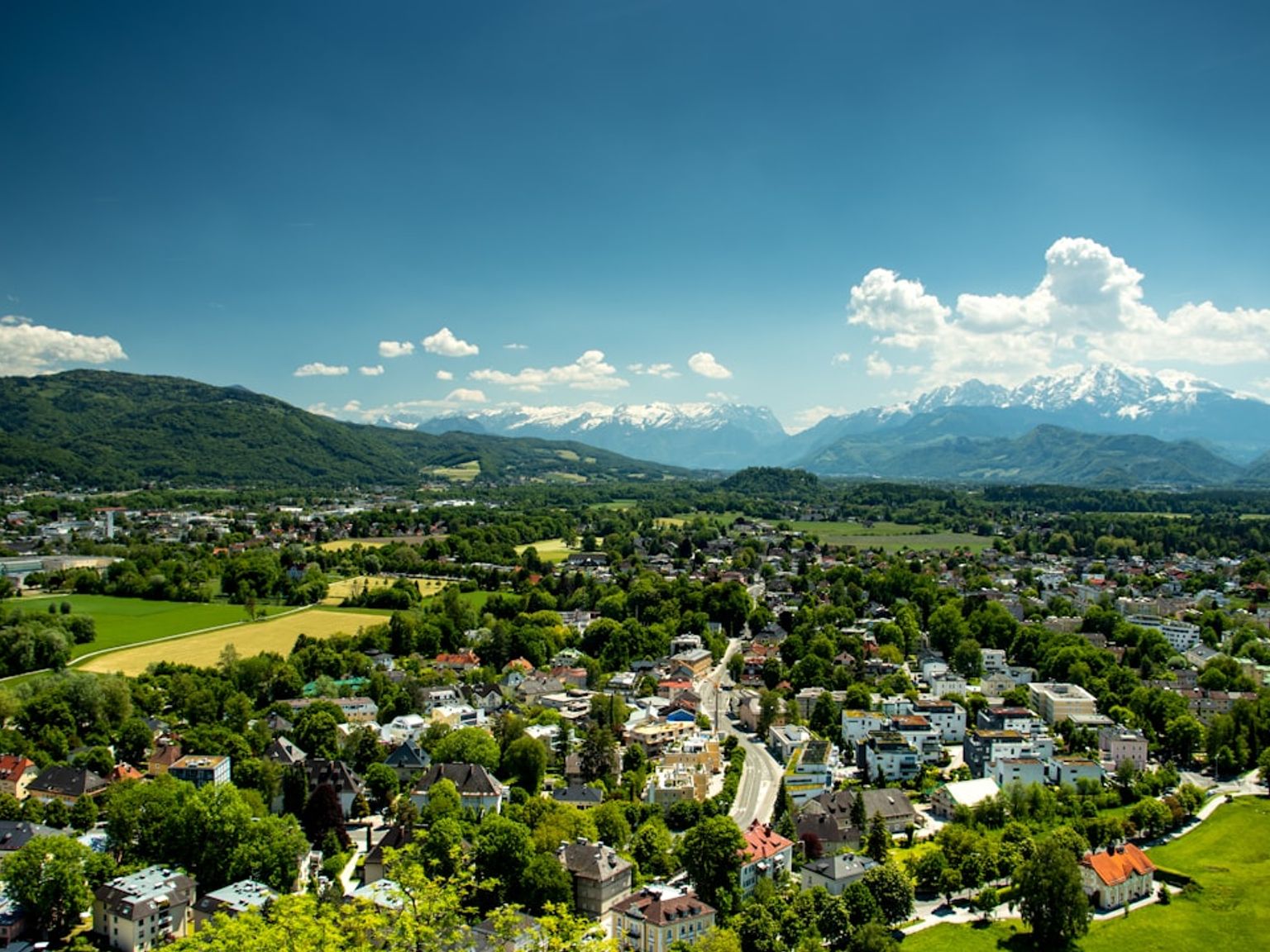en flygvy över en liten stad med berg i bakgrunden.