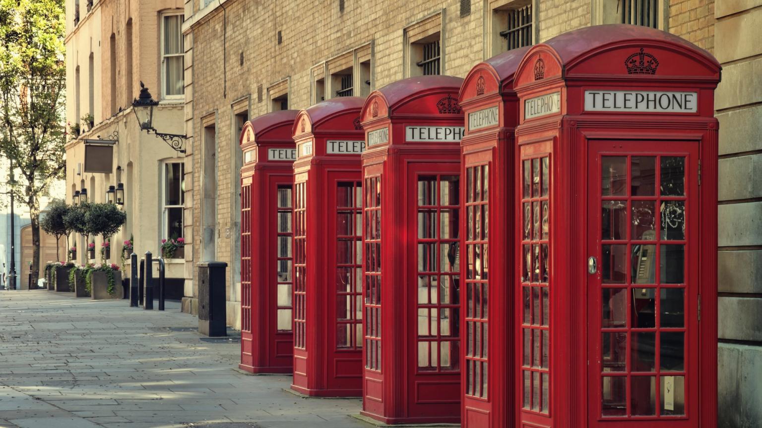 en rad med røde telefonkiosker på en fortau i London