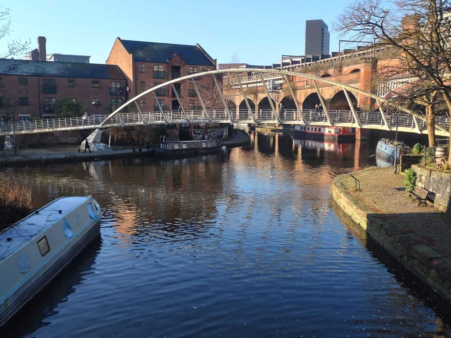 en bro over en elv med en båt i forgrunnen