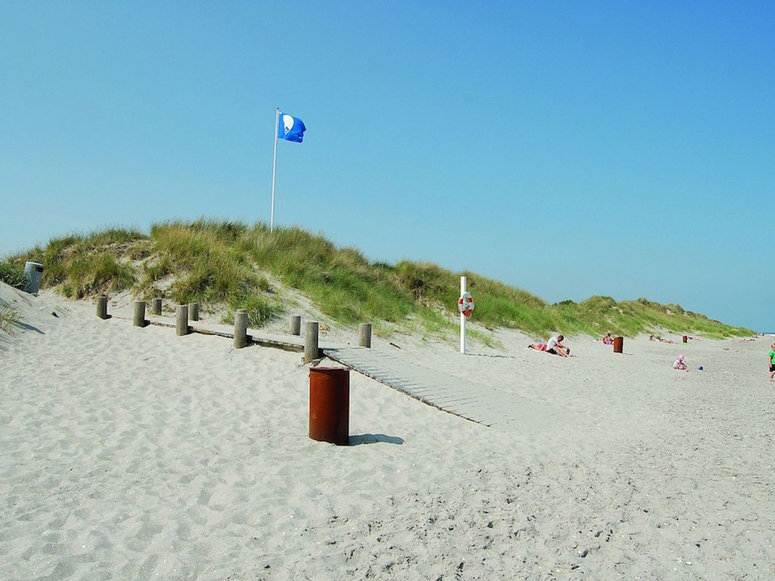 et blått flagg flyr over en sandstrand