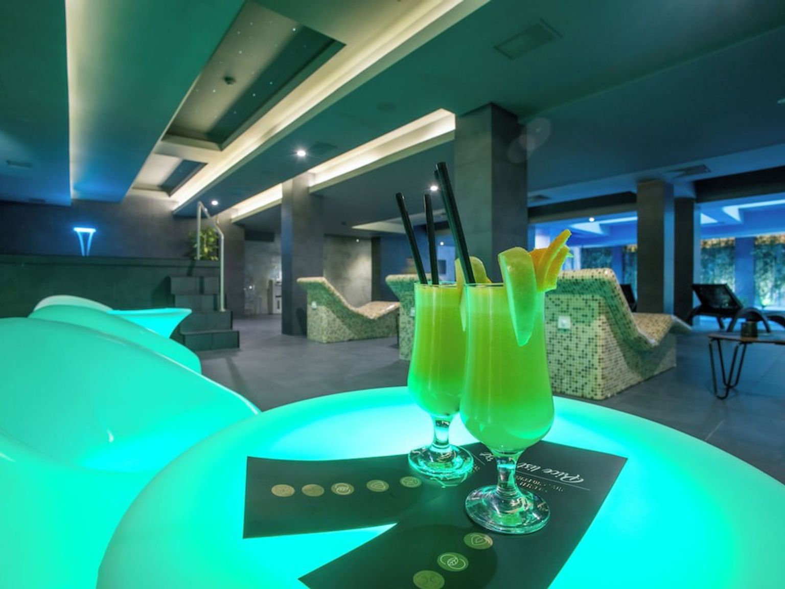 to grønne cocktails med sugerør på et bord i et spa