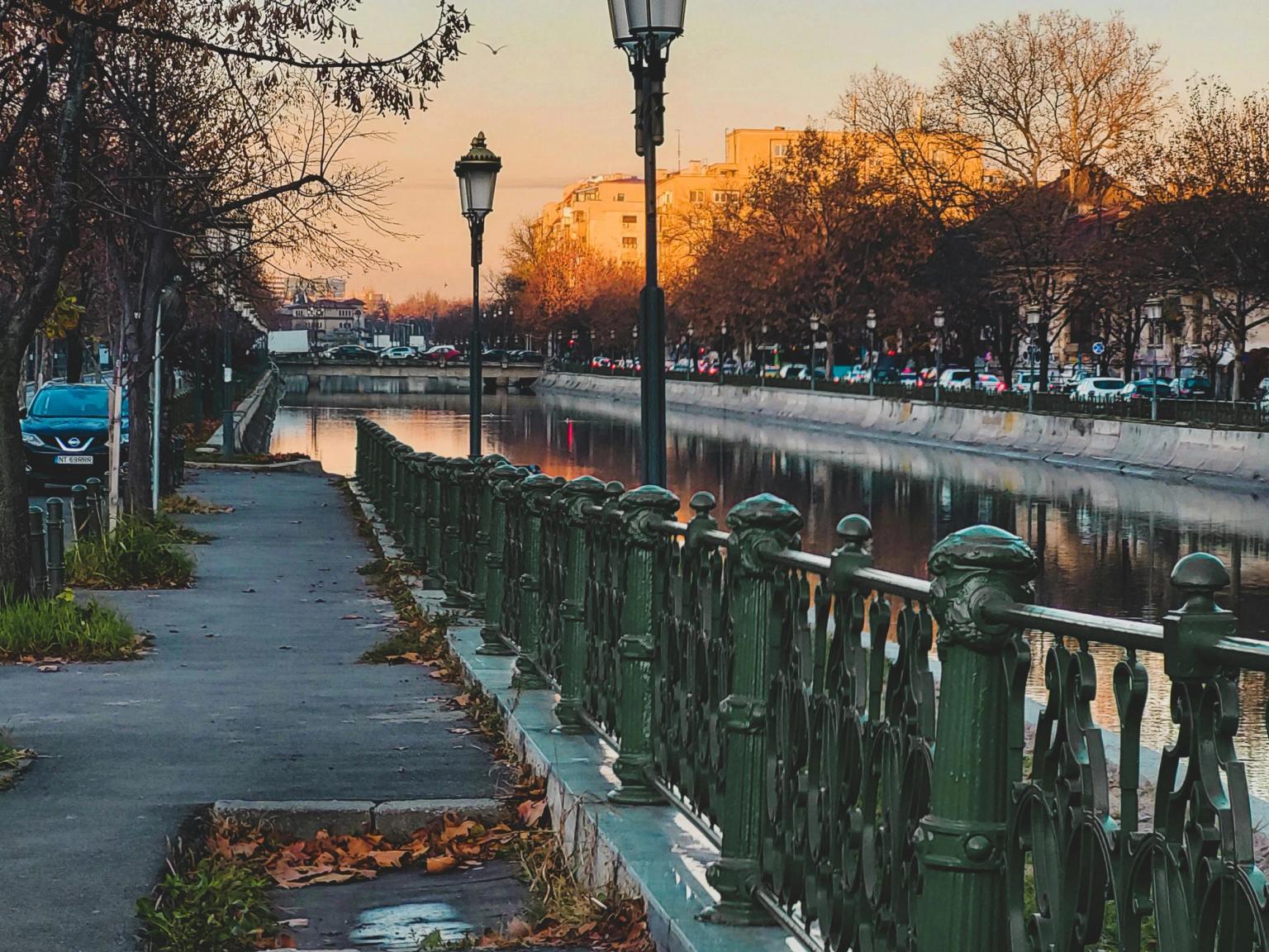 en rad med gatelys langs en fortau ved siden av en elv