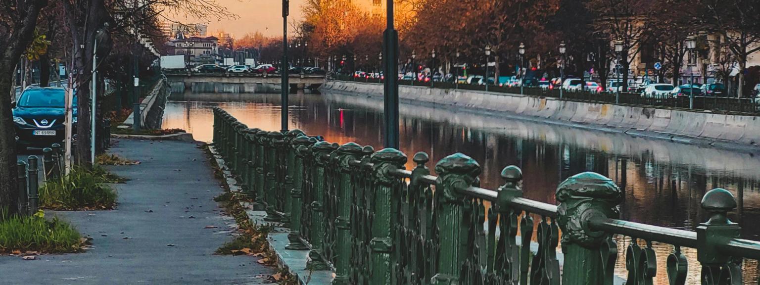 en rad med gatelys langs en fortau ved siden av en elv