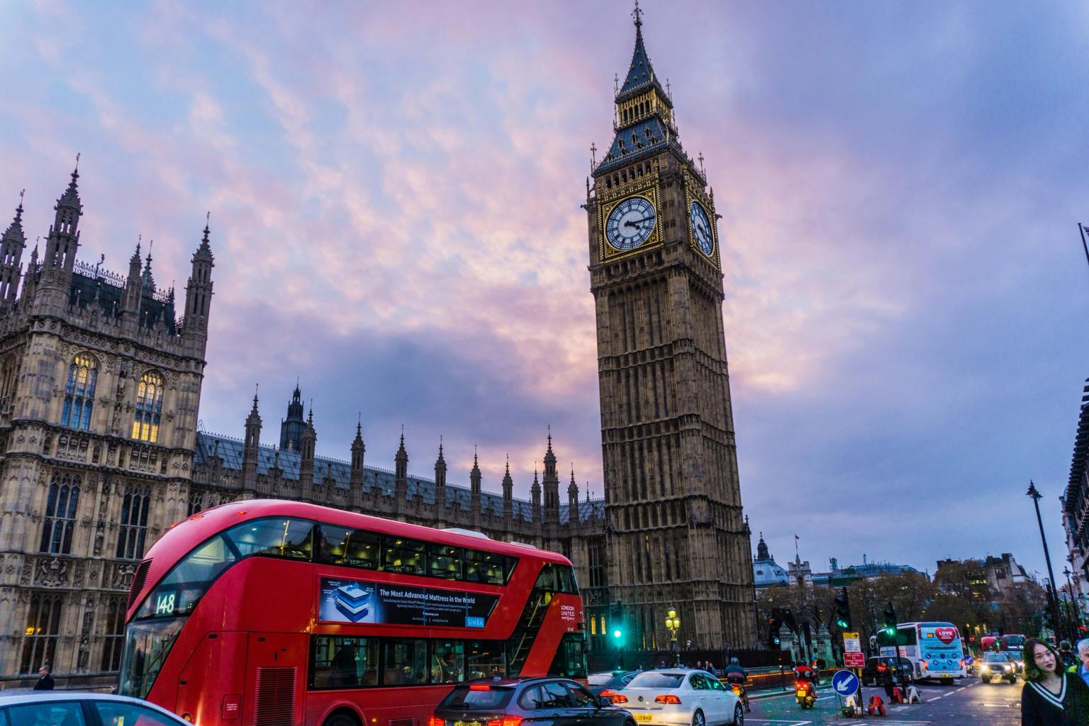 en dubbeldäckare kör förbi Big Ben i London.