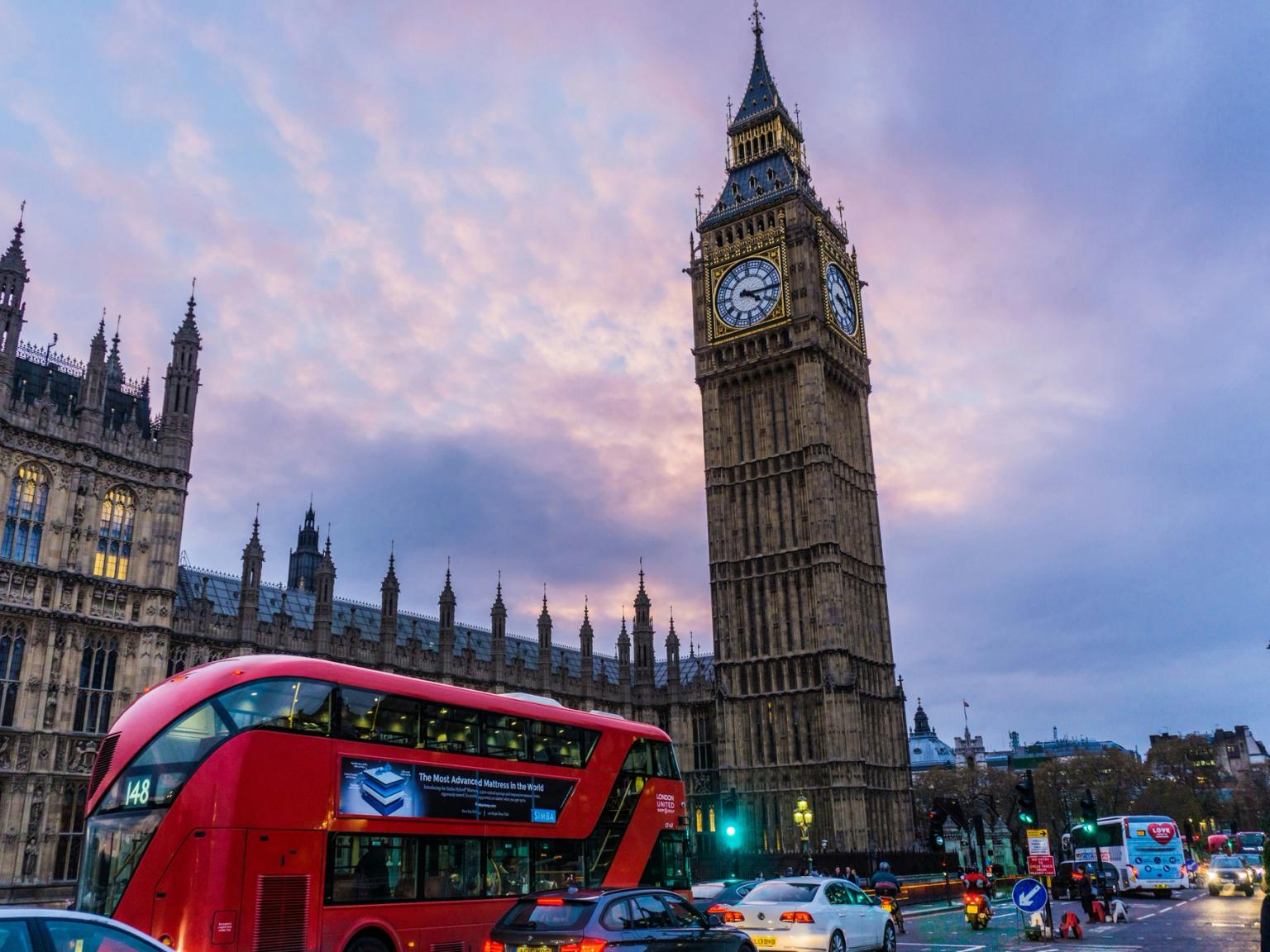 en dubbeldäckare kör förbi Big Ben i London.