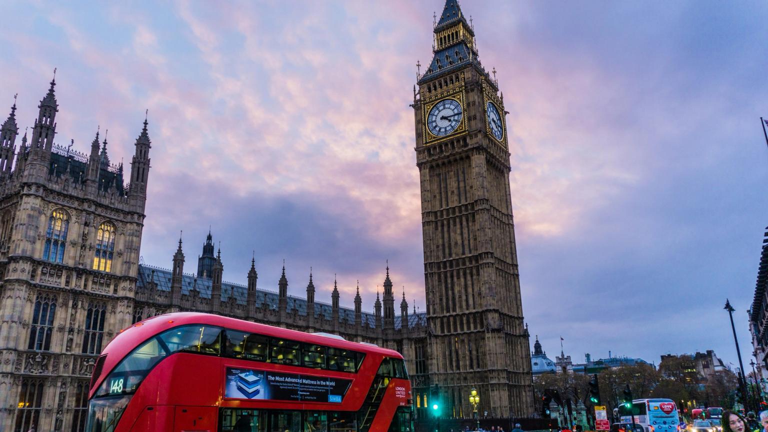 en dubbeldäckare kör förbi Big Ben i London.