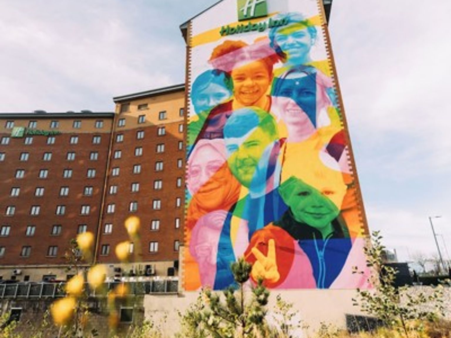 a large colorful mural on the side of a hotel