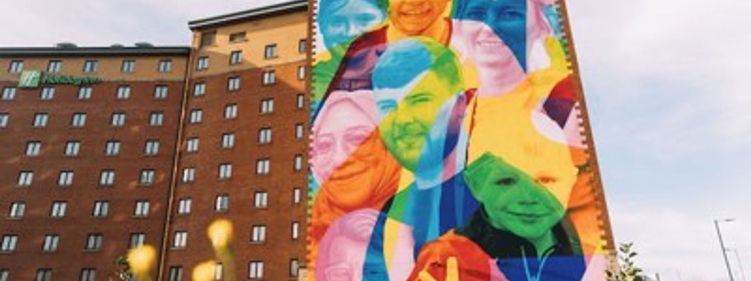 a large colorful mural on the side of a hotel