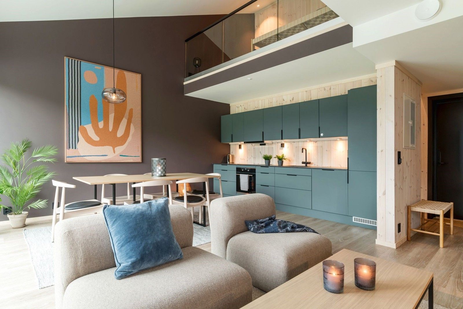 ett vardagsrum med en soffa, stol, bord och kök.