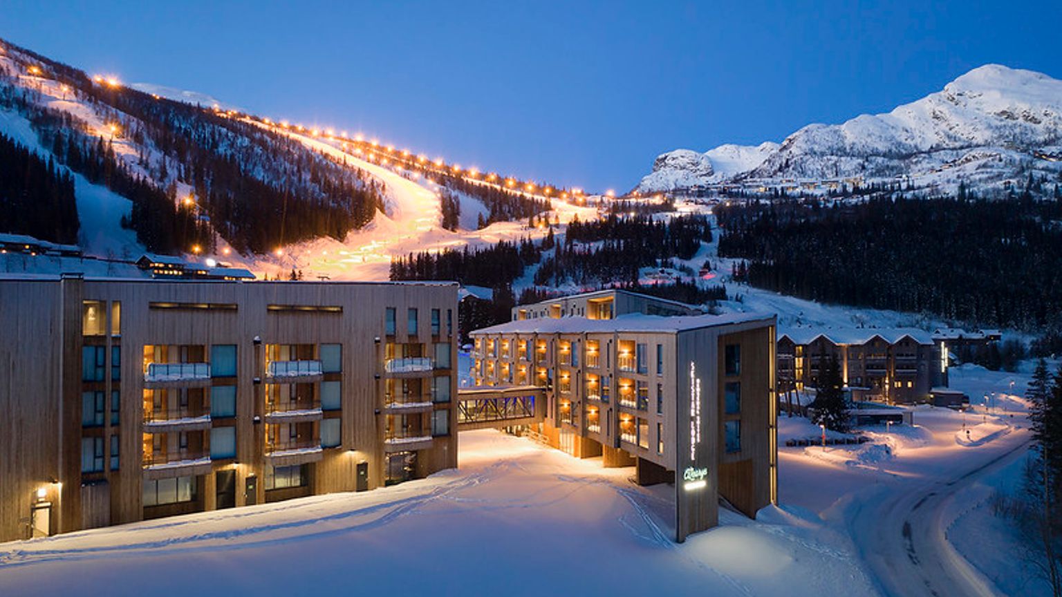 et luftfoto af et skisportssted om natten med en skiløjpe i baggrunden.