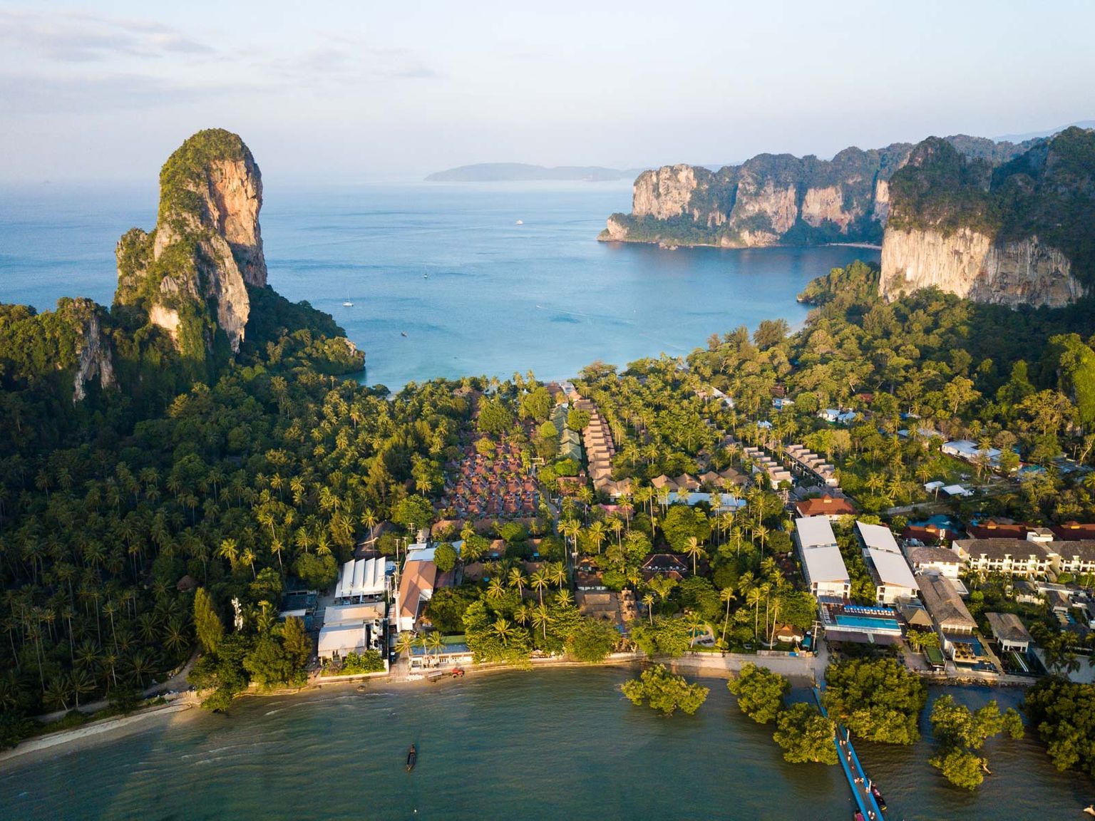 ilmakuva lomakeskuksesta trooppisella saarella keskellä merta.