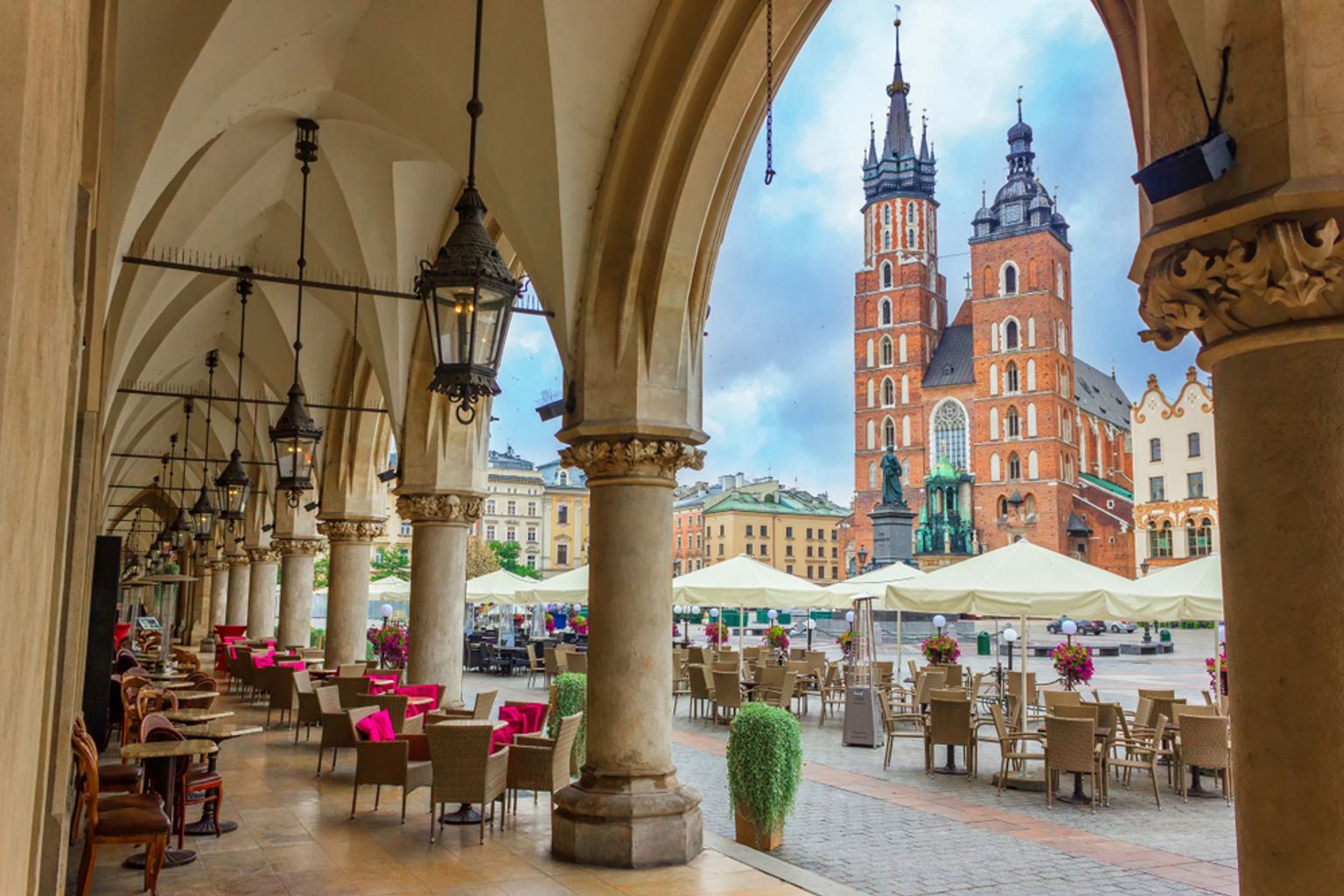 Täckta uteserveringar med utsikt över Krakóws stora marknadstorg och Mariakyrkan.