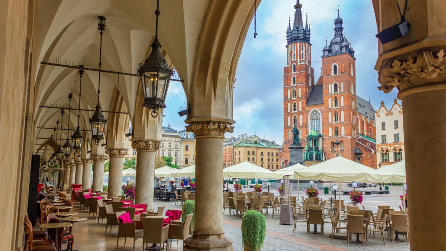 Täckta uteserveringar med utsikt över Krakóws stora marknadstorg och Mariakyrkan.