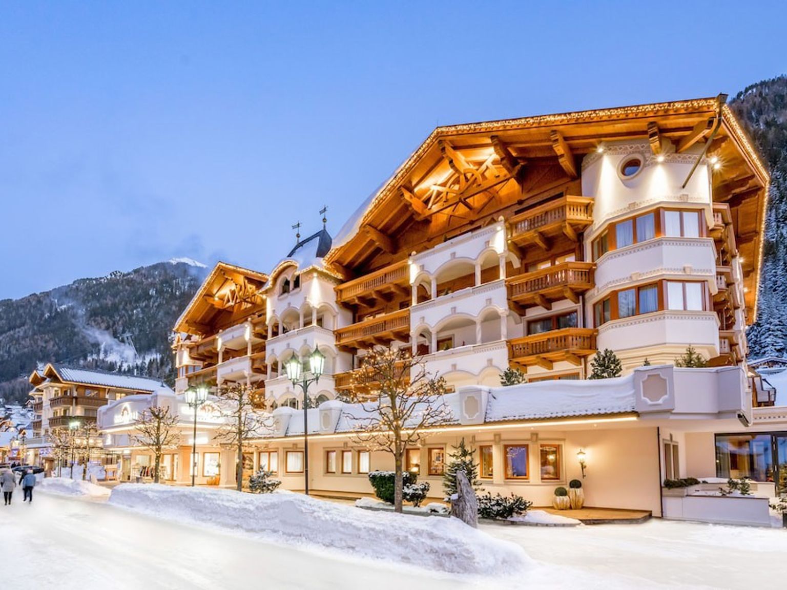 en stor byggnad med många fönster är omgiven av snö, Hotel Trofana Royal, Ischgl