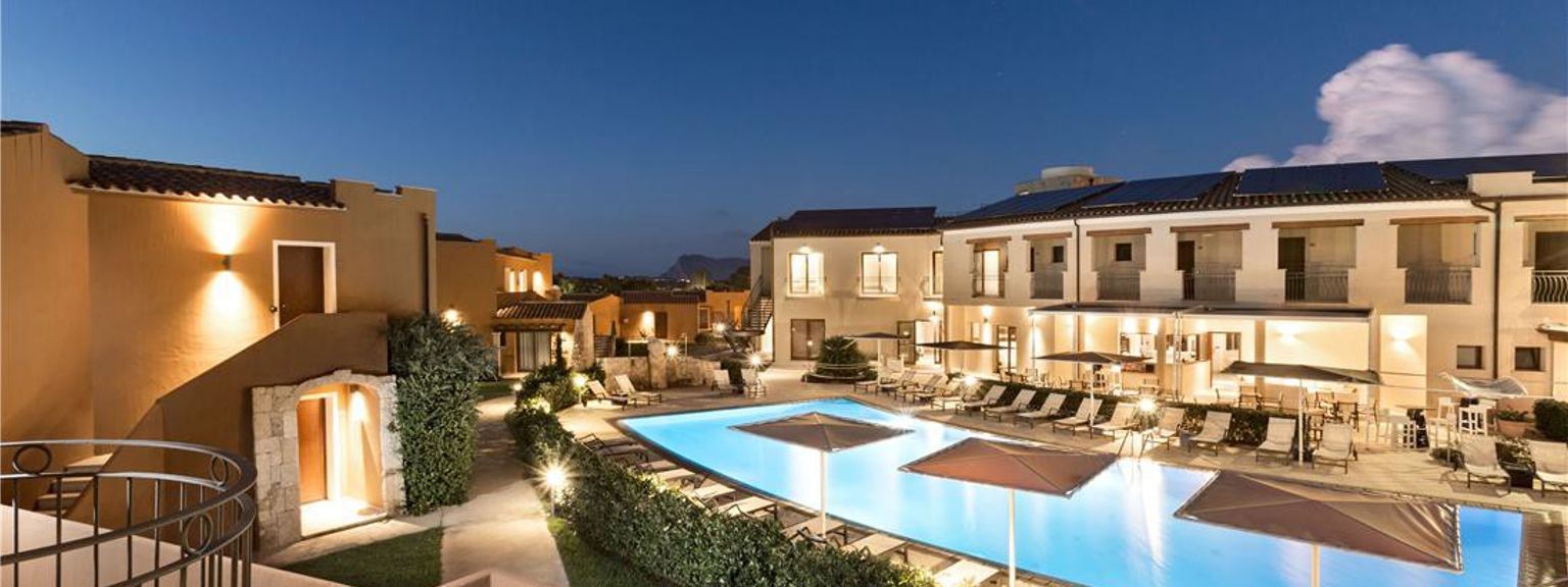 en flygvy av en stor swimmingpool omgiven av byggnader på natten